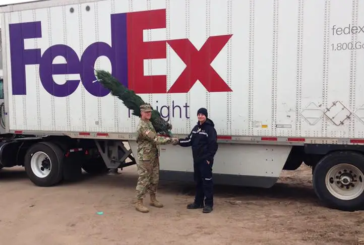 A US military member receiving a Christmas tree